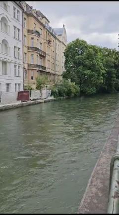 Fluss mit alten Stadthäusern am linken Ufer.